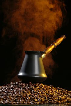 Coffee beans and smoke on a black studio background