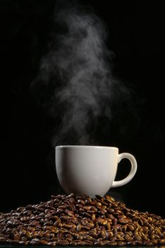 Coffee beans and smoke on a black studio background