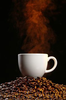 Coffee beans and smoke on a black studio background