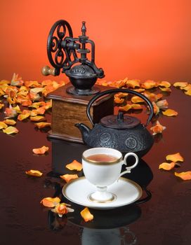 Cup of coffee and flower petals on a glass background