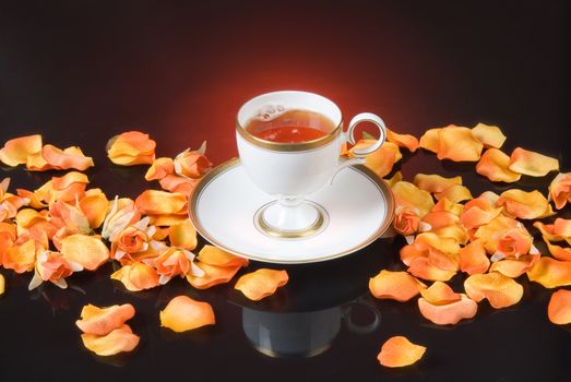 Cup of coffee and flower petals on a glass background