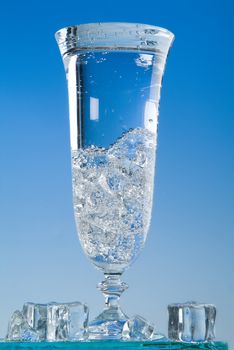 Glass and pouring water on a blue backround