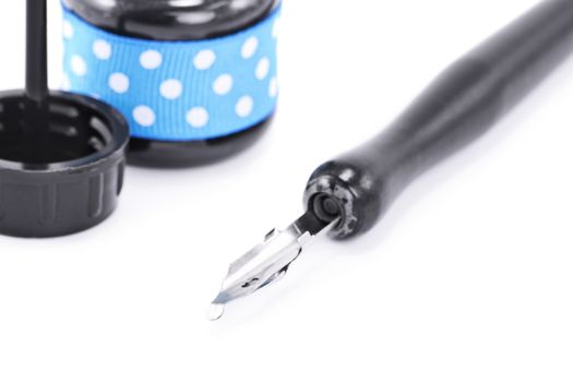 Close up shot of a dip pen and ink bottle, isolated on white background.