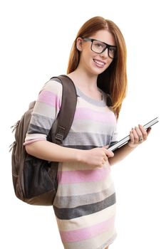 A portrait of a beautiful young female student with glasses and a backpack holding a book, isolated on white background.