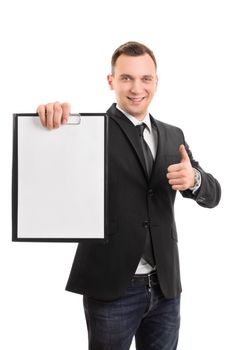 A portrait of a young smiling businessman holding a blank clipboard and showing a thumb up gesture, isolated on white background.