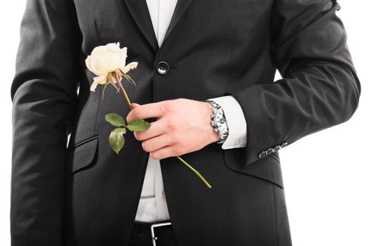 A close up shot of a young man in a suit holding a flower, isolated on white background.
