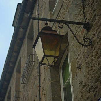 View from bellow on lantern on stone wall with windows