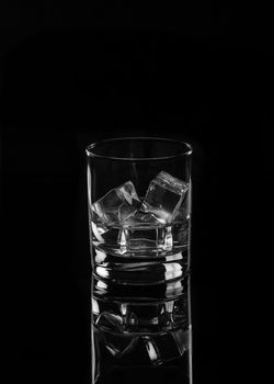 Vodka or gin tonic with ice in rocks glass on black background including clipping path