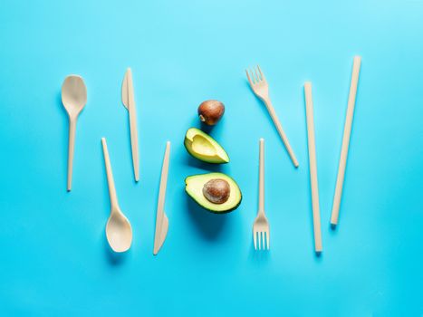 Avocado Seeds Biodegradable Single-Use Cutlery. Bioplastic - Great alternative to plastic disposable cutlery. Minimal concept on blue background.