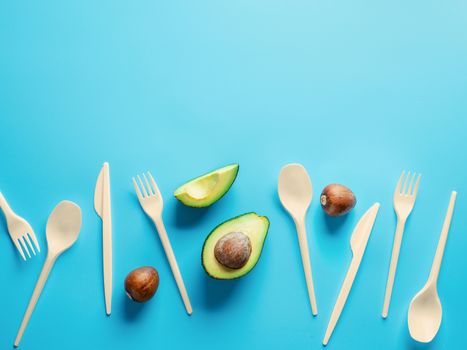 Avocado Seeds Biodegradable Single-Use Cutlery. Bioplastic - Great alternative to plastic disposable cutlery. Minimal concept on blue background. Copy space for text or design