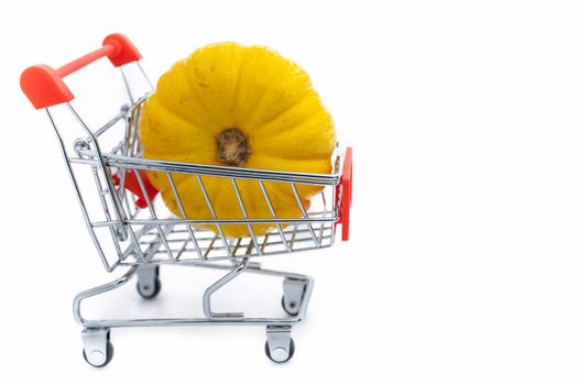 A Fresh orange pumpkin in shopping cart on isolated white background