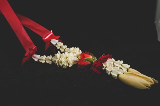 A selected focus Thai traditional jasmine garland. symbol of Mother's day in thailand, to offer the monk or buddha in dark background.