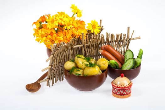 Potatoes, greenery and tableware on isolated satudio background