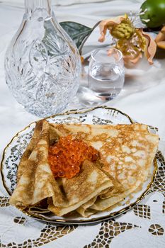 Pancakes with red caviar ona desk