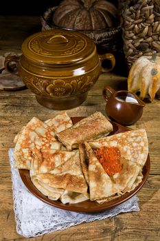 Pancakes with red caviar ona desk