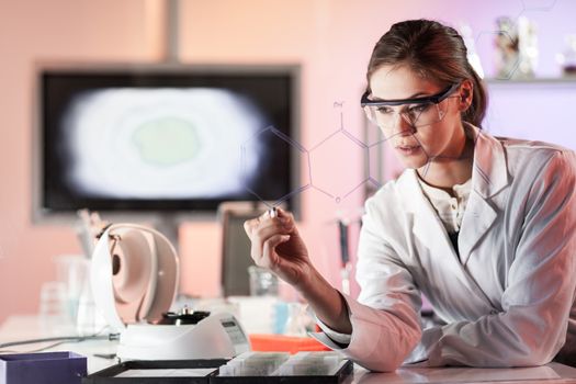 Portrait of a confident female health care expert in life science laboratory writing structural chemical formula on a glass board. Healthcare and modern life science concept. Blue toned image.