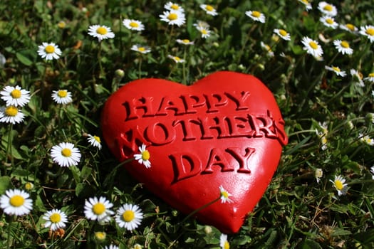 The picture shows happy mother`s day heart in daisy flowers.