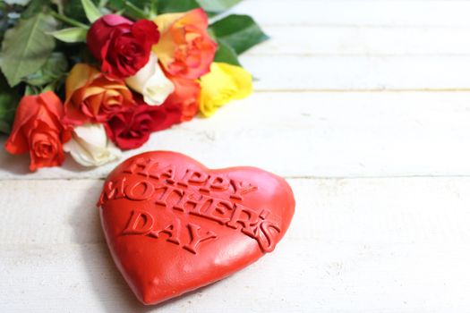 The picture shows a happy mother`s day heart and roses.