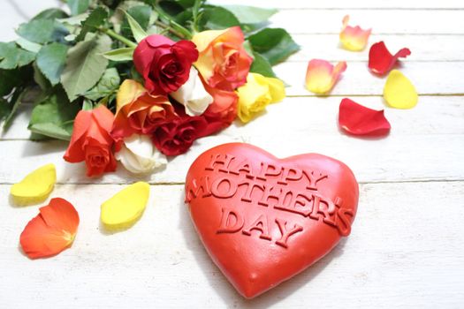 The picture shows a happy mother`s day heart and roses.