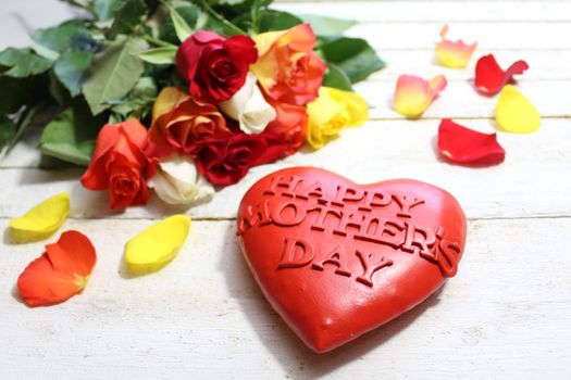 The picture shows a happy mother`s day heart and red roses.