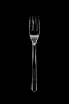 Top view of the transparent plastic fork isolated on black background. With clipping path