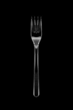 Top view of the transparent plastic fork isolated on black background. With clipping path