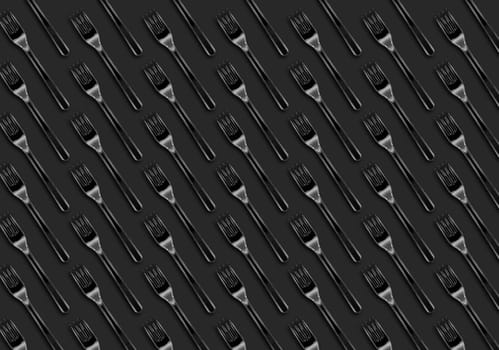 Many transparent plastic forks  on gray background, top view. Disposable table wear concept. Creative top view pattern.