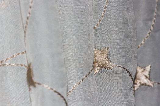 Close-up of white and gold star patterned textile curtain blinds