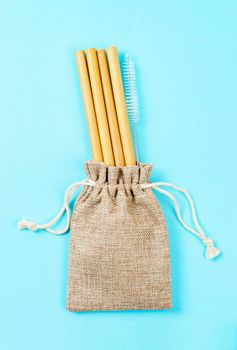 Reusable bamboo straws and cleaning brush in cotton bag. Eco friendly lifestyle concept and Zero waste concept.