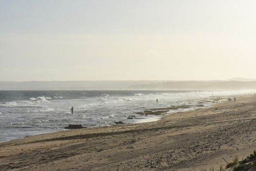 A clear weather summer beach afternoon on the African south coast with fisherman and beach goers, Mossel Bay, South Africa