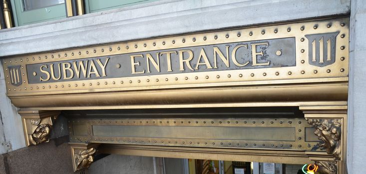 metal subway entrance sign on building in New York city