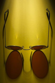 Round sunglasses on the table with yellow coating