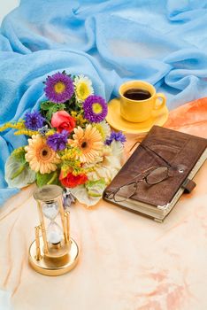 Still life with bouquet of flowers and accessories on a studio background