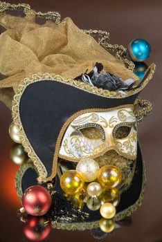 Mask and New Year balls on a glass studio background