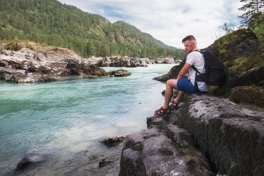 Man resting at river in Altai Mountains territory