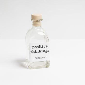 a glass bottle containing  Positive thinkings essence