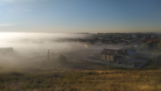 Early morning village in fog. Half village in fog.