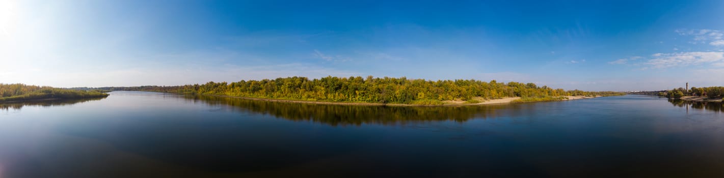 Panorama low over the water surface to the autumn forest