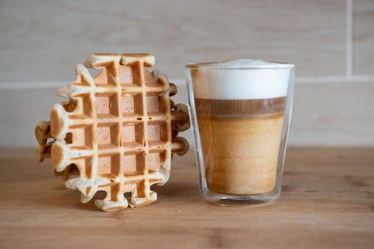 Glass cups of multilayer coffee with mini stroopwafel, syrupwaffles cookies on light gray background with copy space. waffle cookies