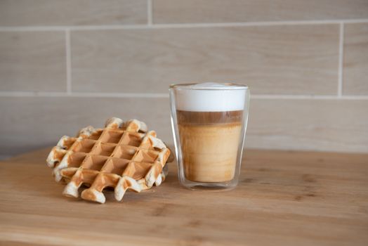 Glass cups of multilayer coffee with mini stroopwafel, syrupwaffles cookies on light gray background with copy space. waffle cookies