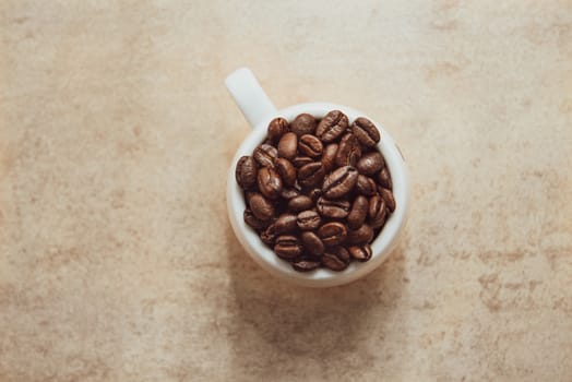 Cup of coffee full of coffee beans.