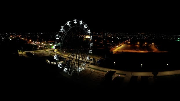 Ferris wheel in a night park. Entertainment in the park