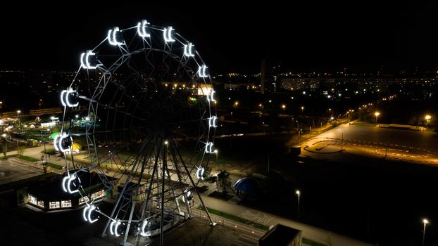 Ferris wheel in a night park. Entertainment in the park