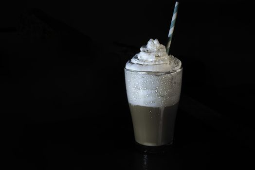 multilayer coffee or cappuccino in a glass cup on black background and free text space