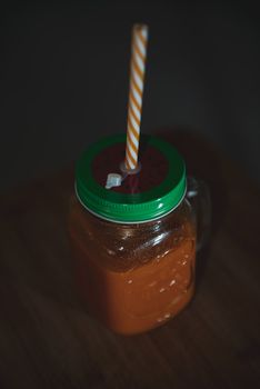 Fresh juicy in mason jar with a straw