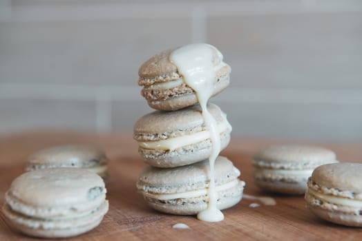 Cake macaron or macaroon with cream on grey background, sweet and colorful dessert.