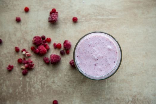 Creative layout made of raspberry, strawberry and coconut smoothie. Food concept. Smoothie on the grey background