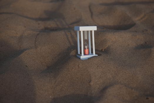 Hourglass on a sand dune beach.