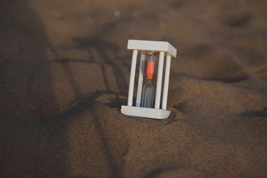 Hourglass on a sand dune beach.