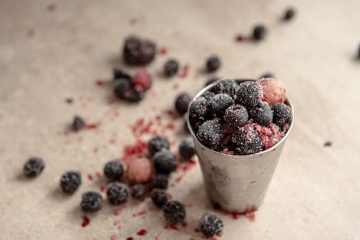 Small bucket with frozen young red berry.